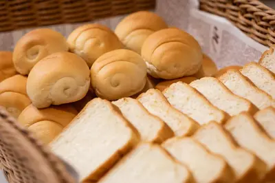 a basket of bread and donuts on a table at Hotel Keihan Asakusa in Tokyo