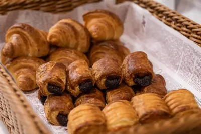 a basket filled with lots of donuts and croissants at Hotel Keihan Asakusa in Tokyo
