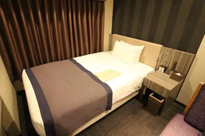 a hotel room with a bed and a side table at Almont Inn Tokyo Nihonbashi in Tokyo