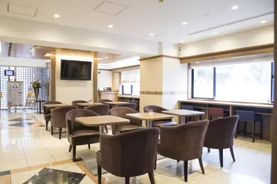 a restaurant with tables and chairs and a television at Almont Inn Tokyo Nihonbashi in Tokyo