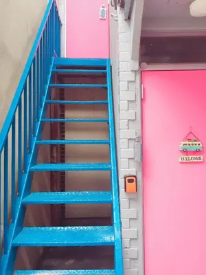 a blue staircase next to a pink door at \u4e16\u7530\u8c37 kamikitazawa sta \u5927\u6676\u5bb6direct to Shinjuku for 13min \u4e0a\u5317\u6ca23\u5206 \u8fd1\u6d89\u8c37\u65b0\u5bbfjust 230m from sta in Tokyo