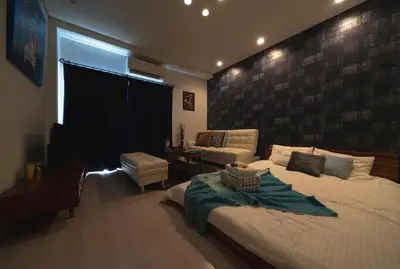 a bedroom with a large bed and a couch at K&K Apartment Kita-Akabane #202 in Tokyo