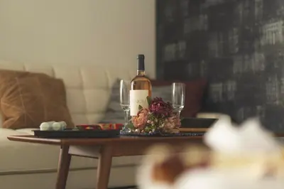 a bottle of wine and glasses on a table at K&K Apartment Kita-Akabane #202 in Tokyo