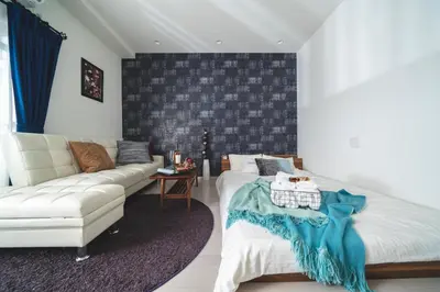 a living room with a couch and a white bed at K&K Apartment Kita-Akabane #202 in Tokyo