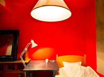 a red bedroom with a table and a lamp at Apartment Hotel Shinjuku in Tokyo