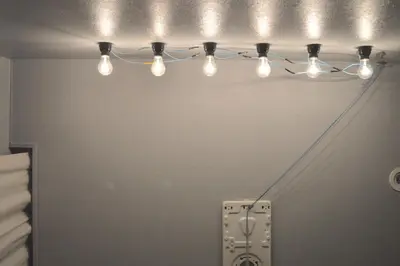 a group of lights hanging from a wall at Apartment Hotel Shinjuku in Tokyo