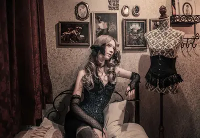 a woman sitting on a bed next to a mannequin at Apartment Hotel Shinjuku in Tokyo