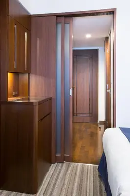 a bedroom with a bed and a desk and a door at Hotel Bellclassic Tokyo in Tokyo
