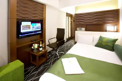 a hotel room with a bed and a flat screen tv at Hotel Bellclassic Tokyo in Tokyo
