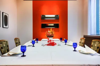 a long table with blue glasses and flowers on it at New Otani Inn Tokyo in Tokyo