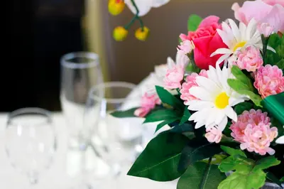 a vase of flowers sitting on a table with glasses at New Otani Inn Tokyo in Tokyo