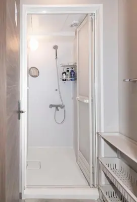 a white bathroom with a shower and a walk in closet at bnb+ Secret Base Mejiro in Tokyo