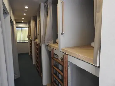 a row of closets in a room with a hallway at bnb+ Secret Base Mejiro in Tokyo