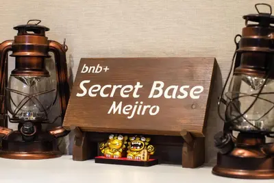 a secret base metro sign next to two lights at bnb+ Secret Base Mejiro in Tokyo