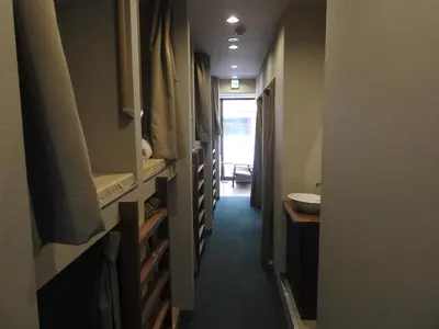 a hallway leading to a bathroom with a sink at bnb+ Secret Base Mejiro in Tokyo