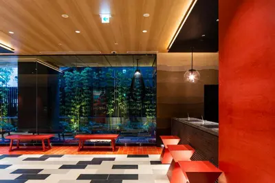 a lobby with red benches and a large window at the b asakusa in Tokyo