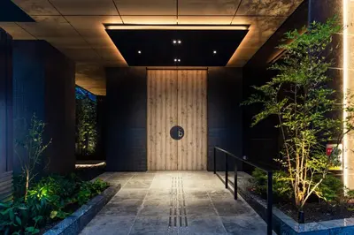 a hallway with a wooden door in a building at the b asakusa in Tokyo