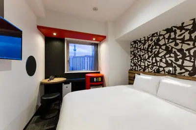a hotel room with a bed and a desk at the b asakusa in Tokyo