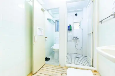 a bathroom with a shower and a toilet at Shinagawa-shuku Guest House & Tours in Tokyo