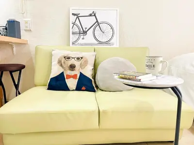 a dog in a suit and glasses pillow on a couch at Shimokitazawa Independent Apartment in Tokyo