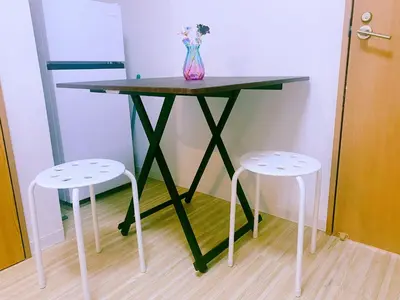 a table with two stools and a vase on it at yikebukuro LuckyHouse \u6c60\u888b\u4e00\u8ed2\u5bb6 \u5e78\u904b\u306e\u5bb6 in Tokyo