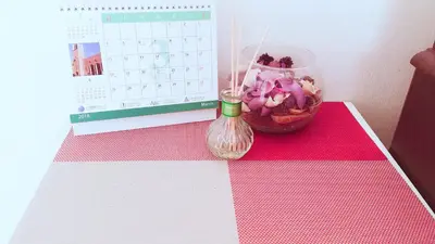 a desk with a calendar and a vase of flowers at yikebukuro LuckyHouse \u6c60\u888b\u4e00\u8ed2\u5bb6 \u5e78\u904b\u306e\u5bb6 in Tokyo