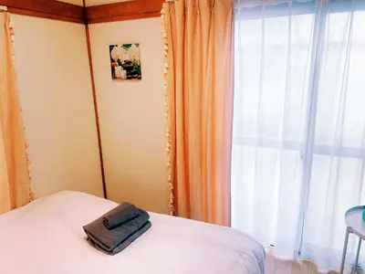 a bedroom with a bed and a window at yikebukuro LuckyHouse \u6c60\u888b\u4e00\u8ed2\u5bb6 \u5e78\u904b\u306e\u5bb6 in Tokyo