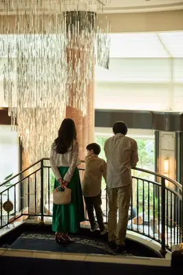 a family walking down a stairway under a chandelier at The Westin Tokyo in Tokyo