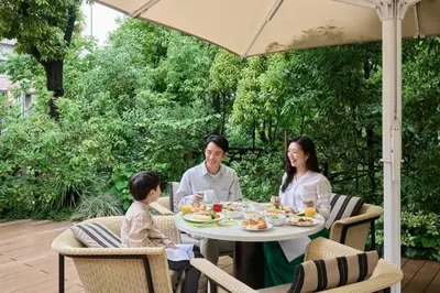 a family sitting at a table under an umbrella at The Westin Tokyo in Tokyo
