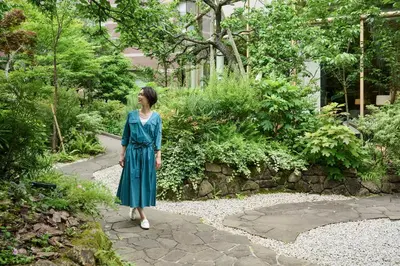 a woman in a blue dress walking down a path at The Westin Tokyo in Tokyo