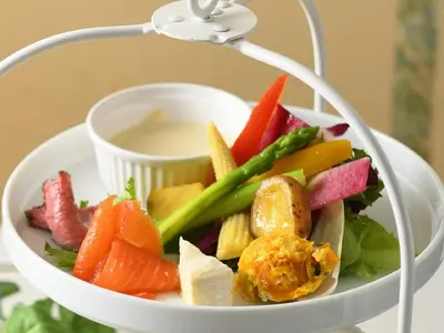 a salad in a bowl with a plate of vegetables at Hotel Monterey Lasoeur Ginza in Tokyo