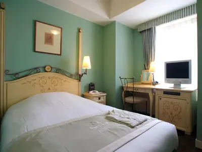 a bedroom with a bed and a desk with a computer at Hotel Monterey Lasoeur Ginza in Tokyo