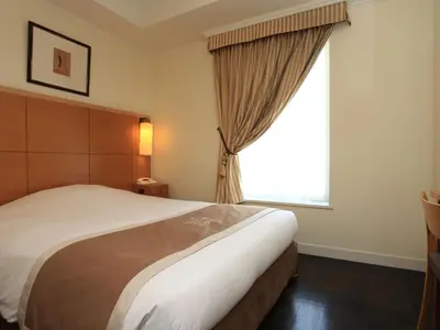 a bedroom with a large bed and a window at Hotel Monterey Lasoeur Ginza in Tokyo
