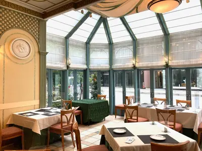 a restaurant with tables and chairs and windows at Hotel Monterey Lasoeur Ginza in Tokyo