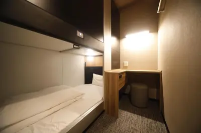 a small room with a bed and a desk at Dormy Inn Korakuen in Tokyo