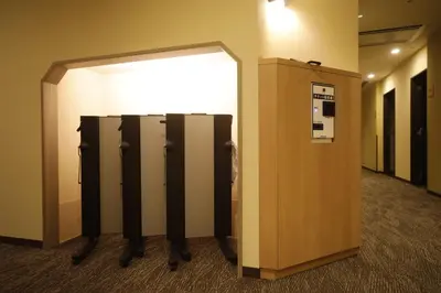 a row of lockers in a hallway in a building at Dormy Inn Korakuen in Tokyo