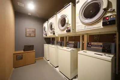 a laundry room with several washers and dryers at Dormy Inn Korakuen in Tokyo
