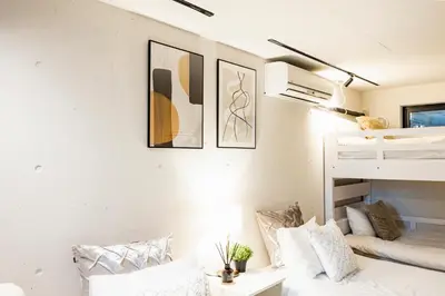 a bedroom with a bunk bed and a bunk bed room with white walls at RiriLeo Koenji in Tokyo