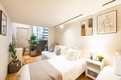 two beds in a room with white walls at RiriLeo Koenji in Tokyo