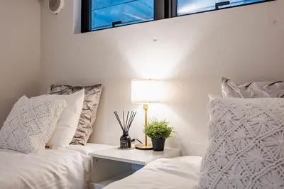 a bedroom with two beds and a table with a lamp at RiriLeo Koenji in Tokyo