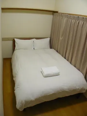 a bed with a white towel on top of it at Hotel Meigetsu in Tokyo