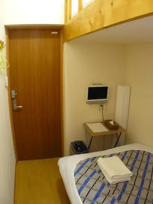 a bedroom with a bunk bed and a desk with a computer at Hotel Meigetsu in Tokyo