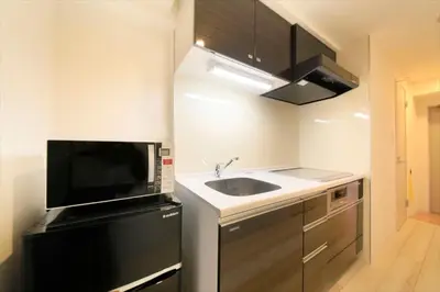a small kitchen with a sink and a microwave at Bay Hotel Urayasu-ekimae in Urayasu