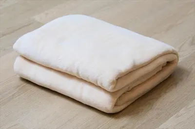 a stack of white towels sitting on a wooden floor at Bay Hotel Urayasu-ekimae in Urayasu