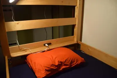 an orange bed in a room with a mirror at Guest house SHIE SHIMI in Tokyo