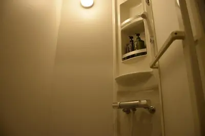 a bathroom with a door with a sink and a light at Guest house SHIE SHIMI in Tokyo
