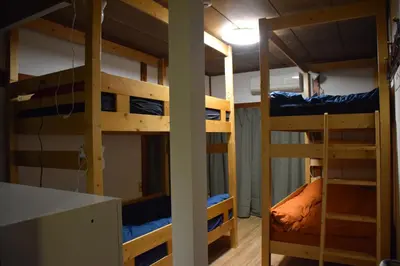 a room with three bunk beds in a room at Guest house SHIE SHIMI in Tokyo