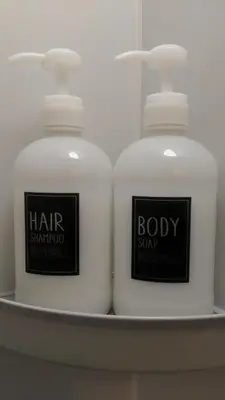 two white bottles of soap on a shelf at Base Inn Uguisudani in Tokyo