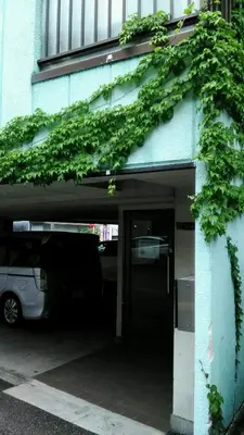 a garage with a car parked under a building at Base Inn Uguisudani in Tokyo