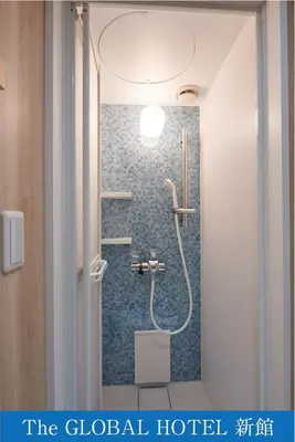 a bathroom with a shower with a toilet at The Global Hotel Tokyo in Tokyo